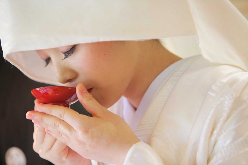 綿帽子の新婦が三々九度を行う