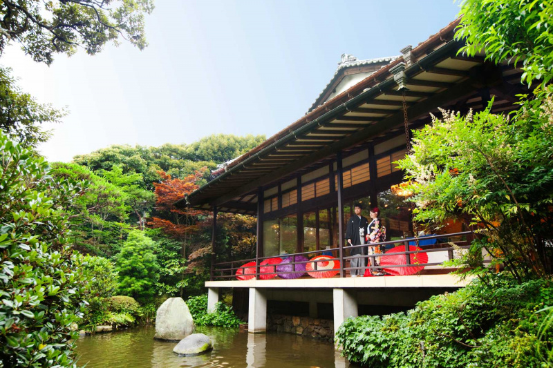 池の前に立つ和装の新郎新婦